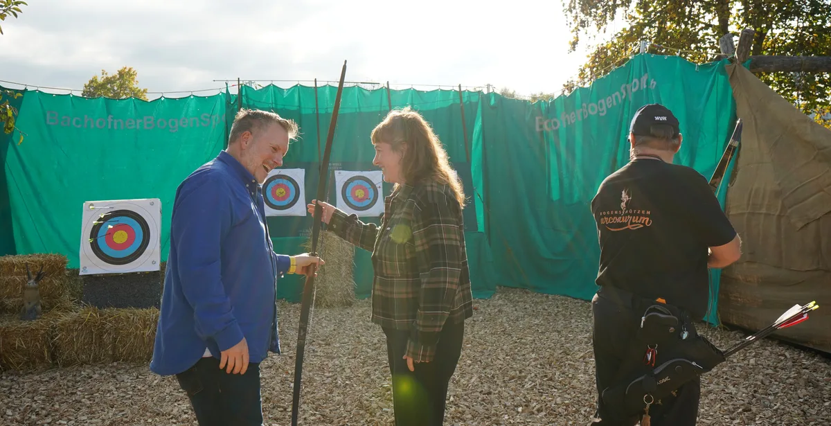Zwei Personen, die einen Bogen halten. 
